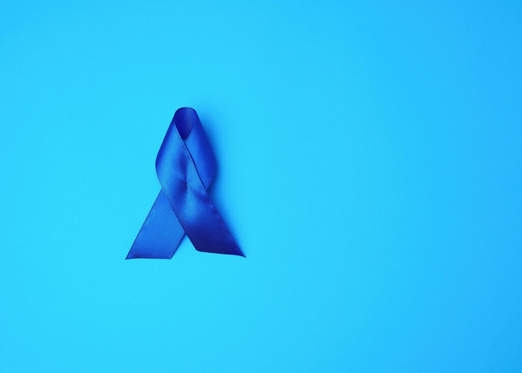 Dark blue ME awareness ribbon on blue background.